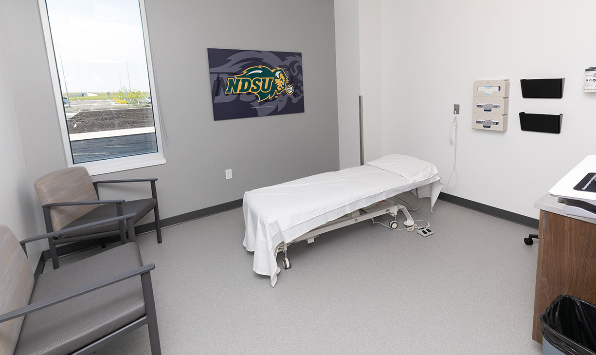 physical therapy examination room with a bed and two chairs