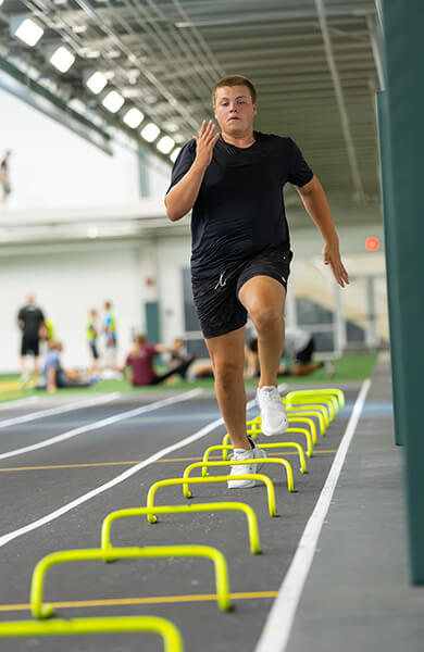Athlete running over mini hurdles