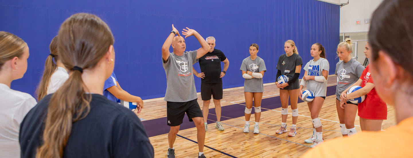 Coach showing volleyball team how to set