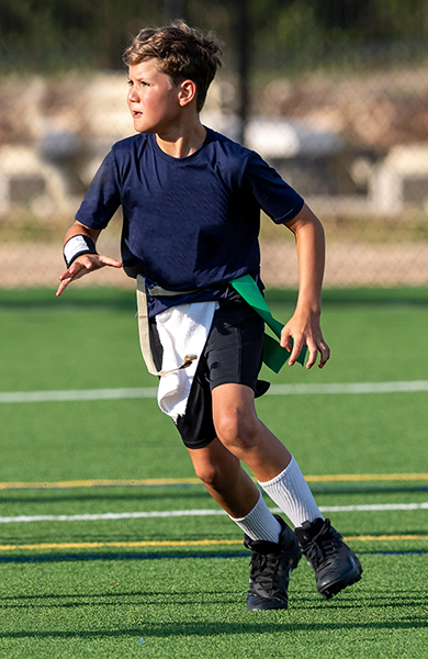 young boy playing flag football